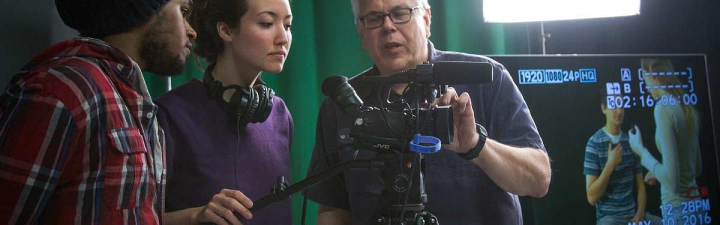 Three people looking in a camera