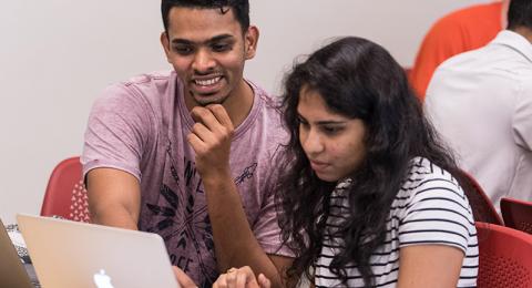 International students looking at a computer 