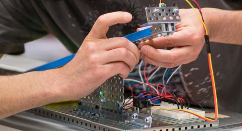 Student connecting electrical circuitry in control systems and components class