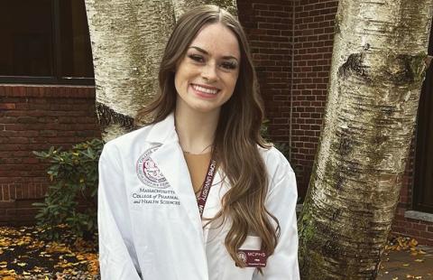 UNH Manchester neuropsychology graduate Tristen Witkowski '22 poses in her lab coat from MCPHS University
