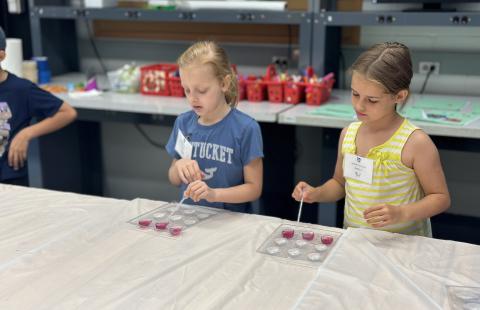 Students pipetting liquid into heart-shaped molds.
