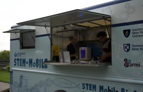 The STEM-MoBILE with the window open, showing science equipment inside. 