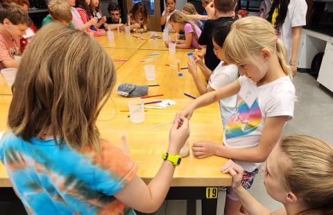 Campers performing an experiment with STEM-MoBILE Staff.