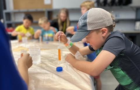 Campers performing an experiment with STEM-MoBILE Staff.