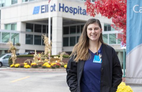 student stands outside Elliot Hospital where she works as an LNA