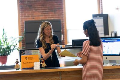 Katie Hannagan and student at registration office desk