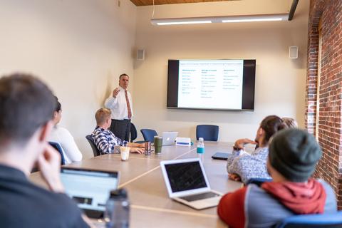 Business Professor Bill Troy teaches students at UNH Manchester