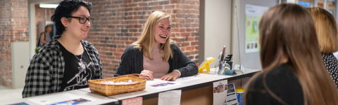 Students smiling at engagement desk
